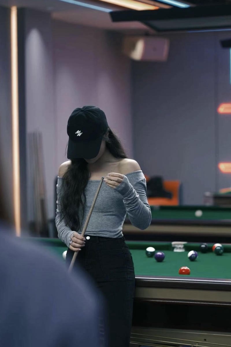 Hình con gái chơi bi da che mặt giữa không gian giải trí